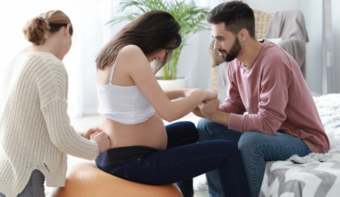 A birth Doula assisting a woman during labor and pregnancy, alongside the woman's partner.